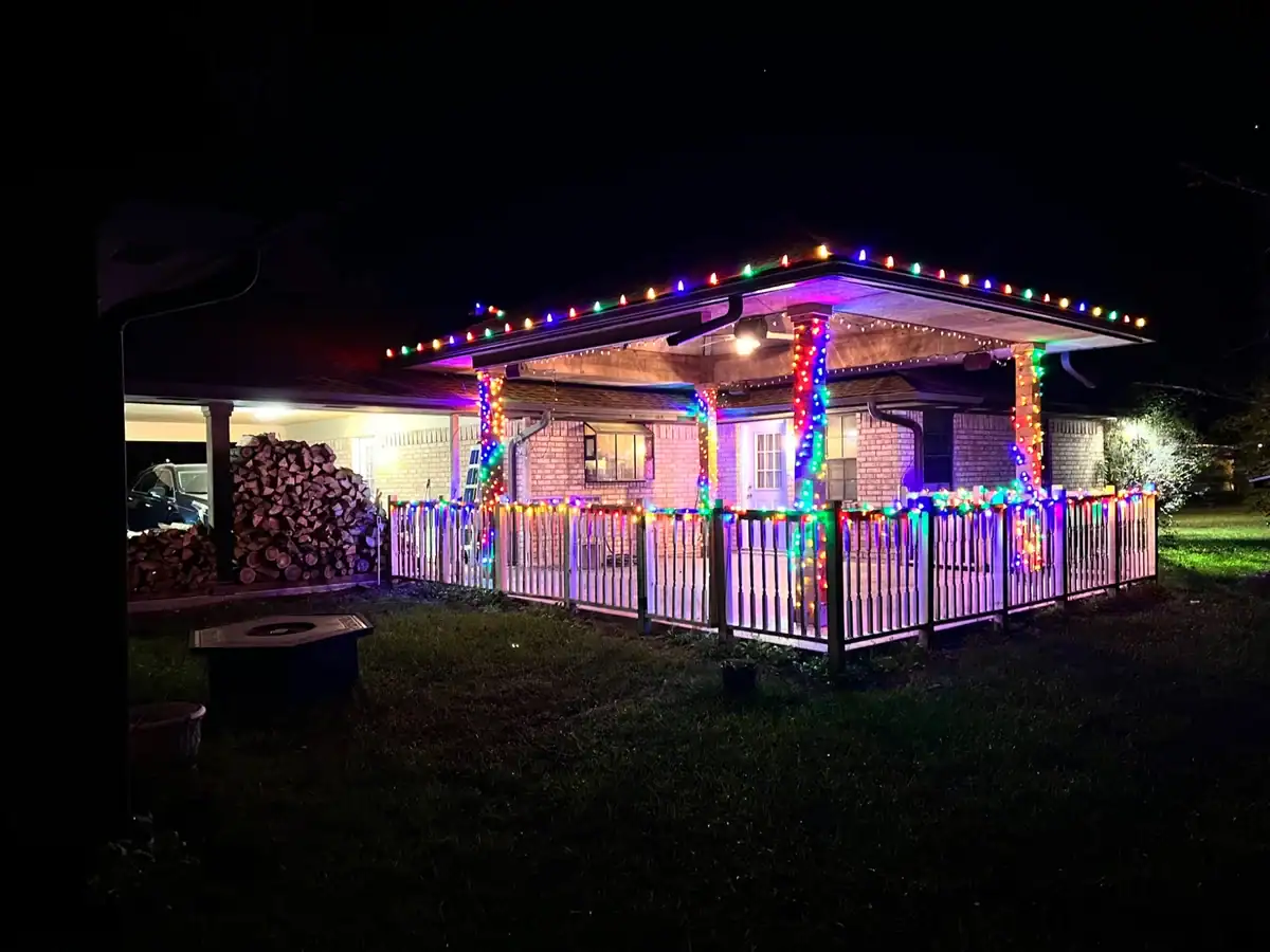 A front porch and roofline decorated with multicolor Christmas lights